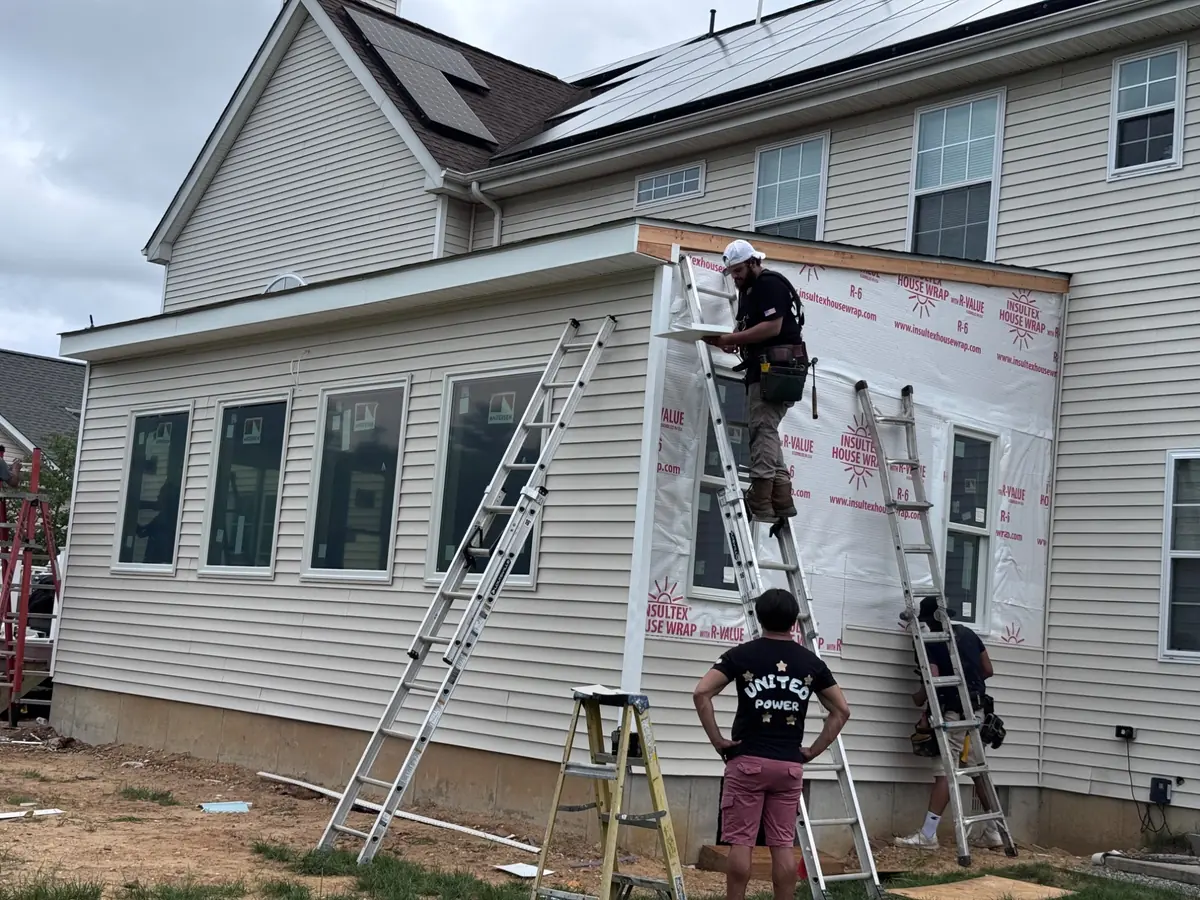 The ECUSACR LLC crew installing siding on a home addition